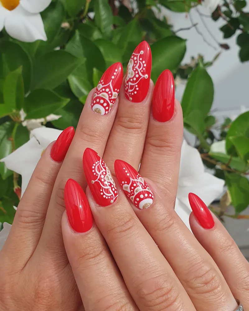 Rote Nägel mit weißer Ornament-Handmalerei