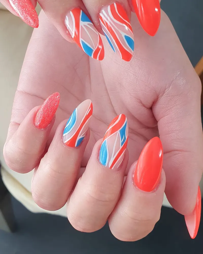 Korallrote Mandelnägel mit Wellen-Motiven in Blau, Weiß und Orange
